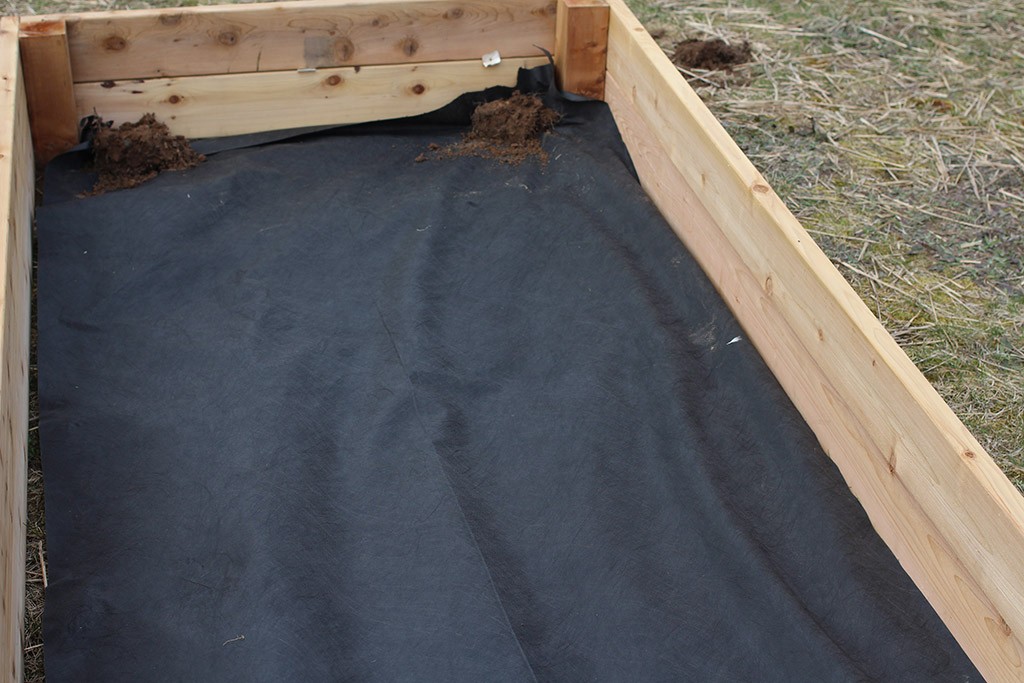 landscaping cloth inside a large raised garden bed