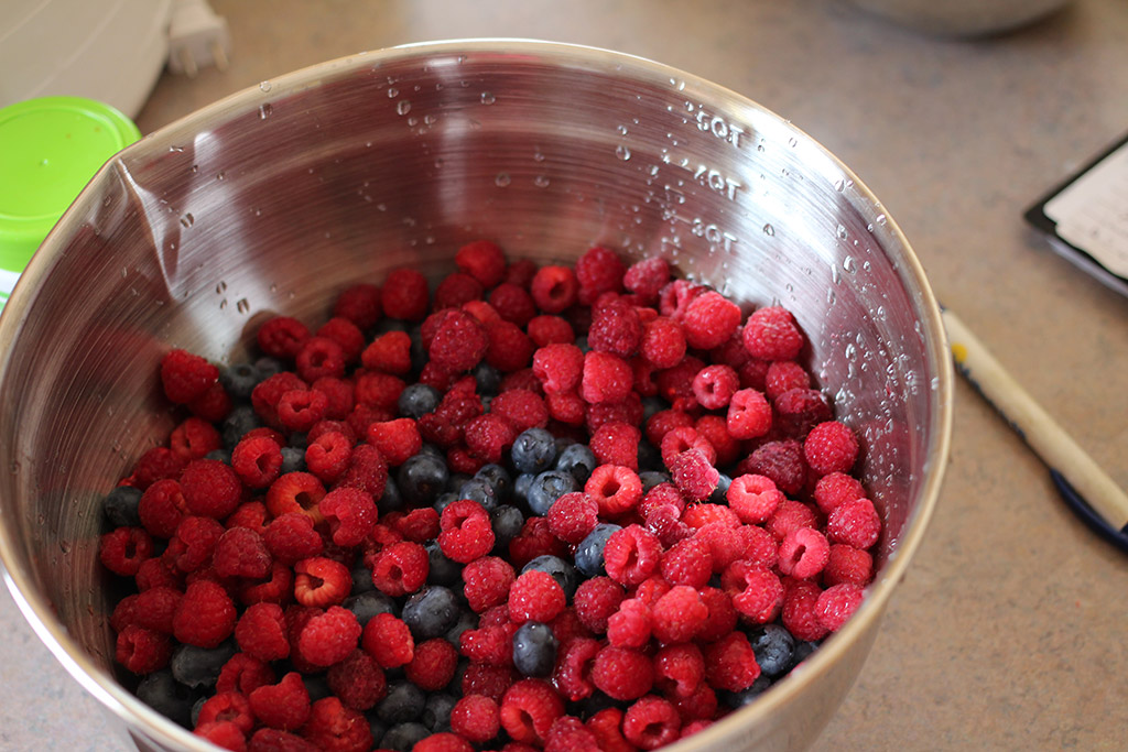 Raspberries, blueberries, and strawberries ready for jam mashing